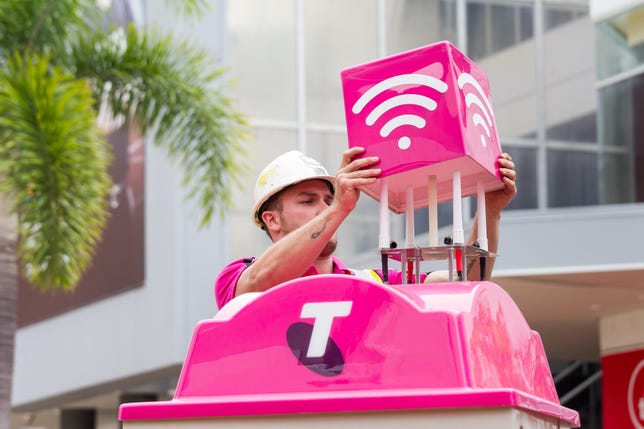 A Telstra technician installs a 5G-enabled public Wi-Fi hotspot