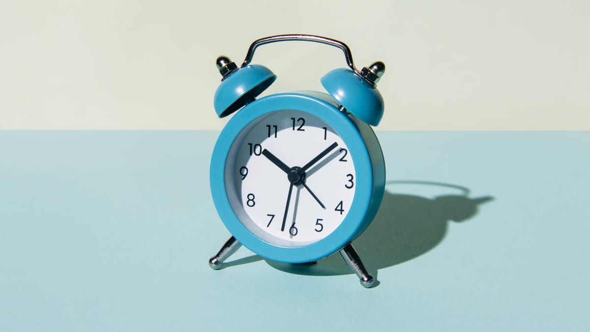 A bright blue analog alarm clock