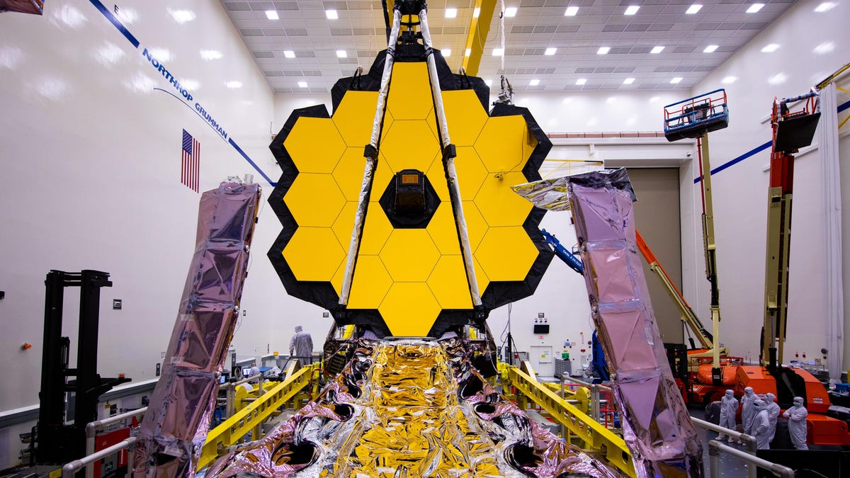 James Webb Space Telescope with its large golden mirror fully opened in a test facility.