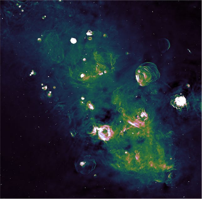 Radio observation of a portion of the Milk Way with diffuse stretch of green and bubbles of gas representing supernova remnants.