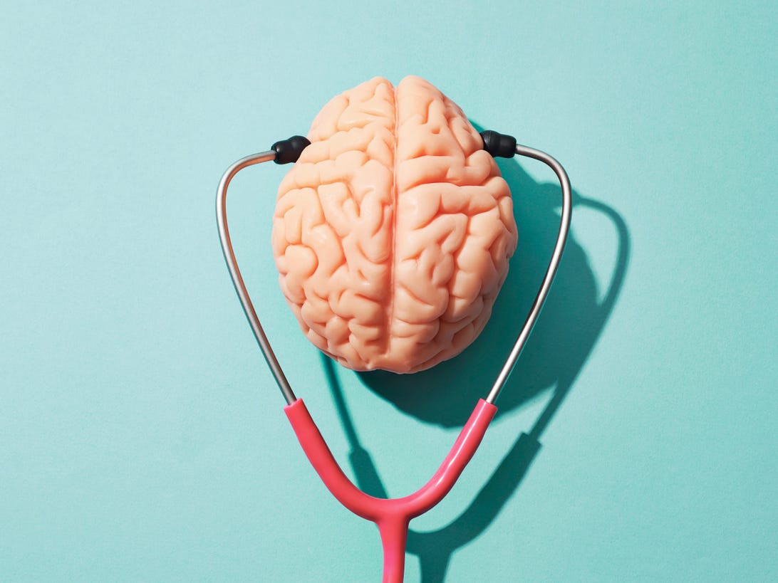 brain with a stethoscope against a light blue background.