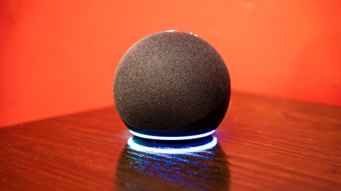 Ein Amazon Echo Dot vor orangefarbenem Hintergrund
