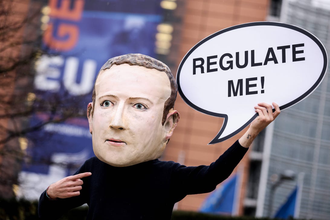 An activist wearing a mask depicting Facebook CEO Mark Zuckerberg during an action marking the initial announcement of the Digital Services Act in Brussels in 2020.