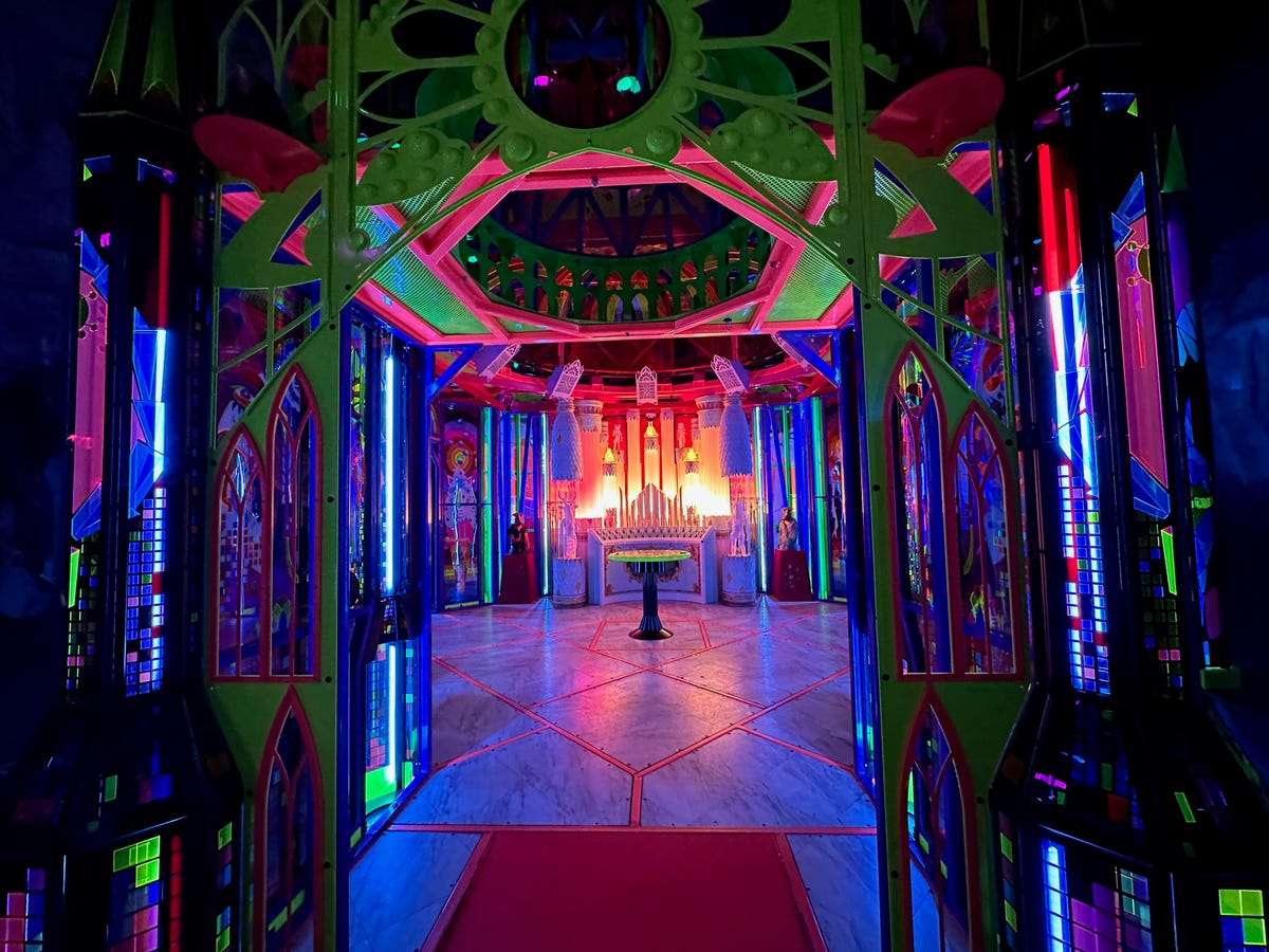 A glowing cathedral-like art space, colored in rainbow hues.