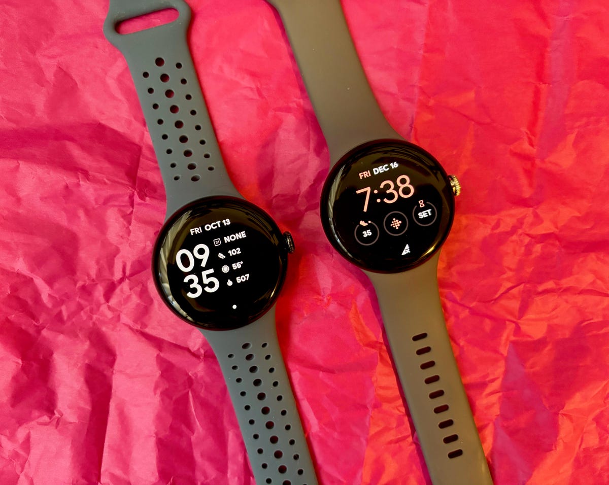 The Pixel Watch 2 (left) next to the Pixel Watch (right) on a pink background