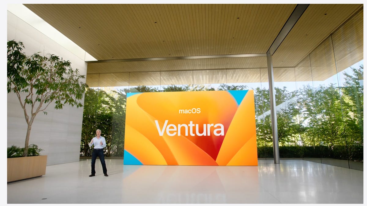 Apple presenter next to giant MacOS Ventura logo of a stylized California poppy