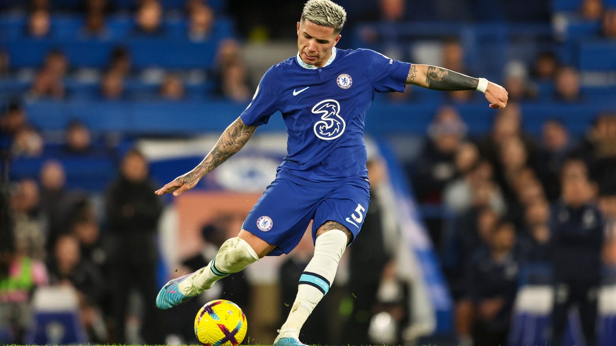 Chelsea midfielder Enzo Fernández kicks a ball with his right foot.