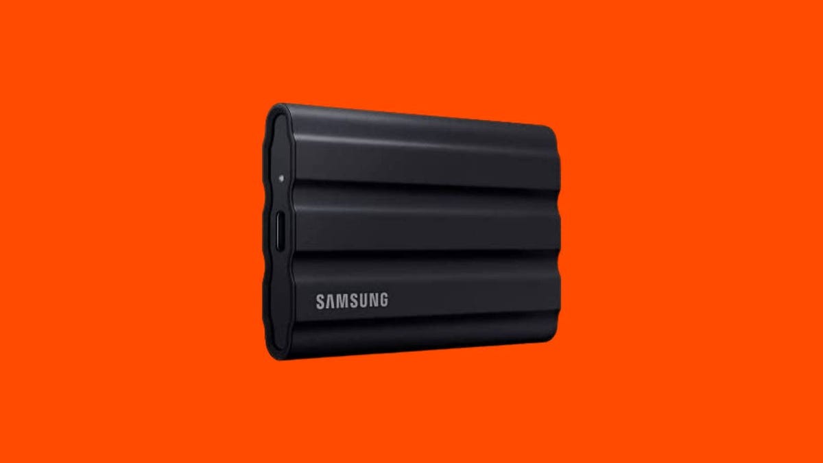 A black Samsung external SSD against an orange background.