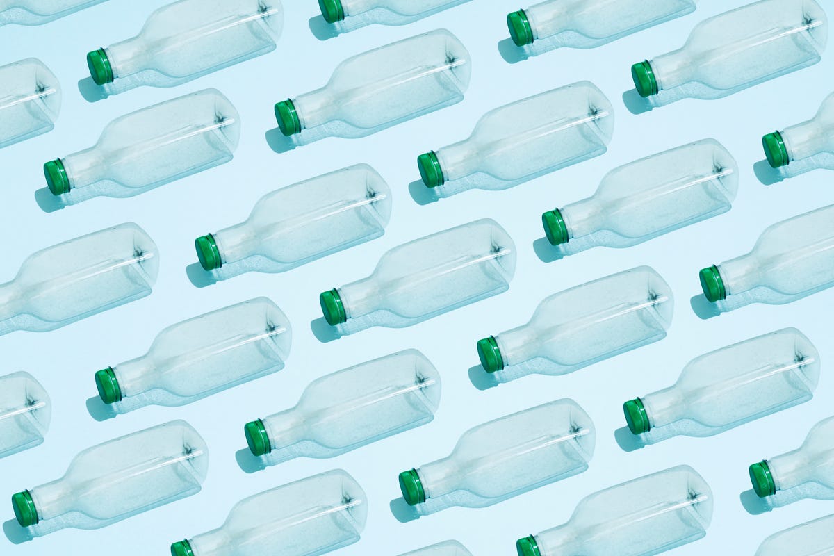rows of empty plastic water bottles on blue background