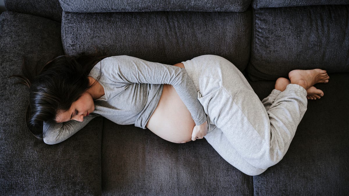 Pregnant person lying on a sofa.