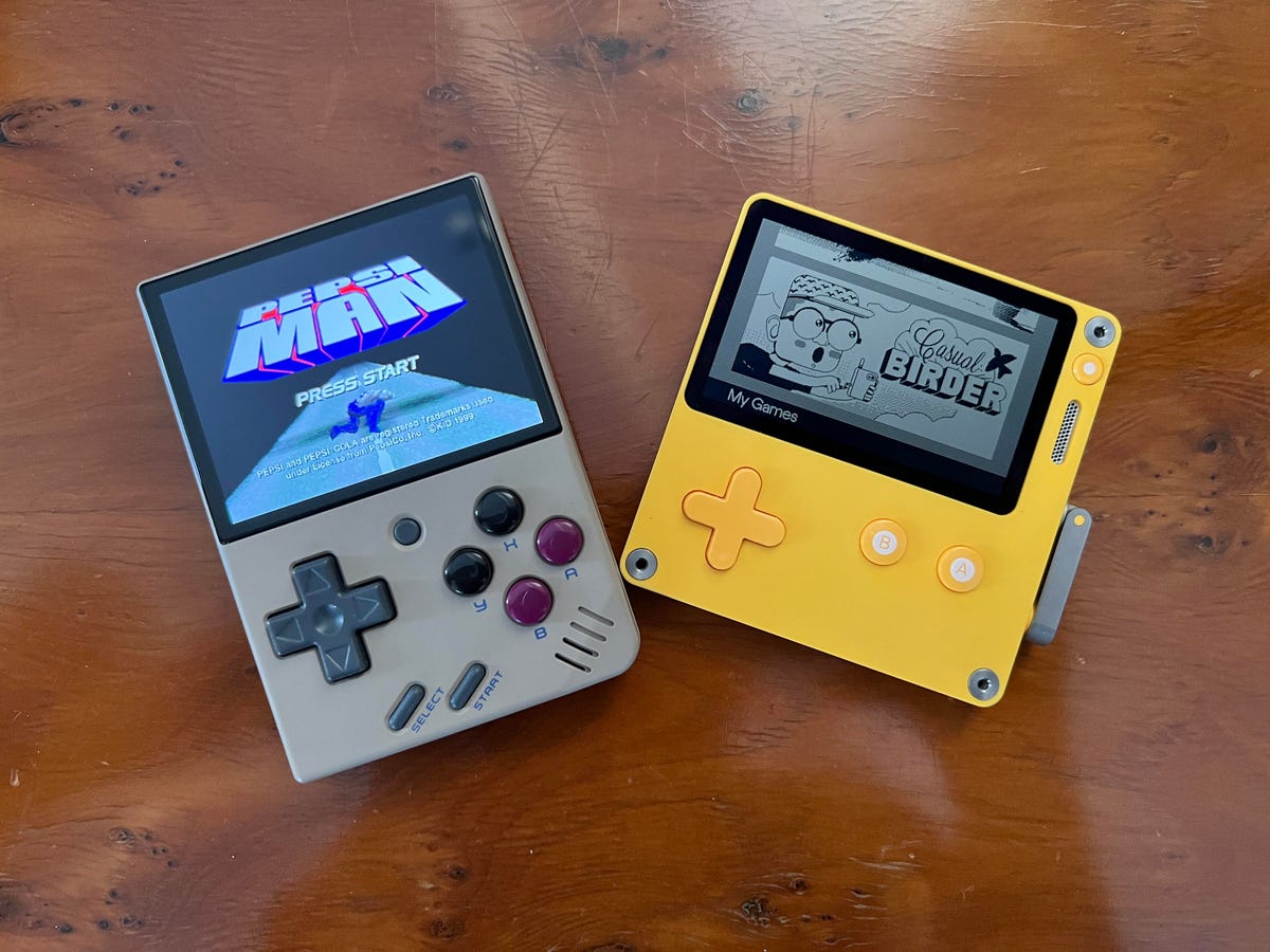 Miyoo Mini and Panic Playdate game handhelds on a wooden table