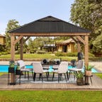 Wood patio gazebo covering set of chairs outside