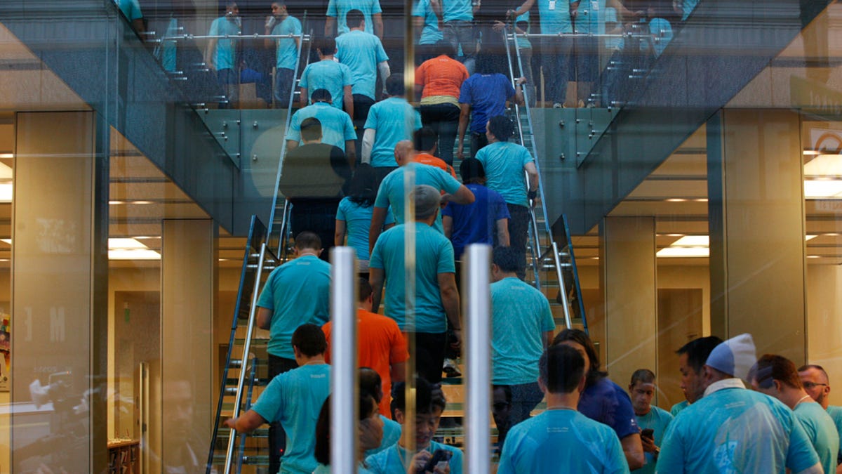  Apple employees dressed in blue and orange prepare for an iPhone launch day