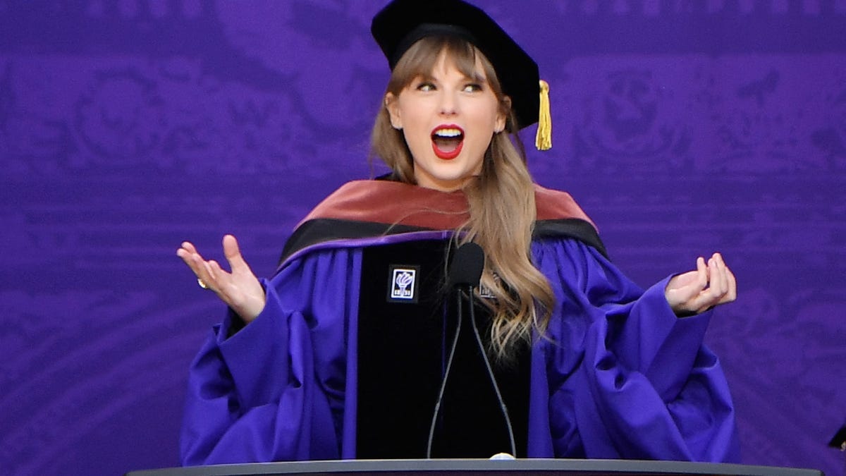 Taylor Swift in cap and gown, speaking at NYU commencement