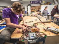 <p>A student competitor on the Highland Robotics team works on a circuit board for a robot.</p>