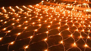 Orange Waterglide outdoor Halloween net lights are displayed across a lawn.