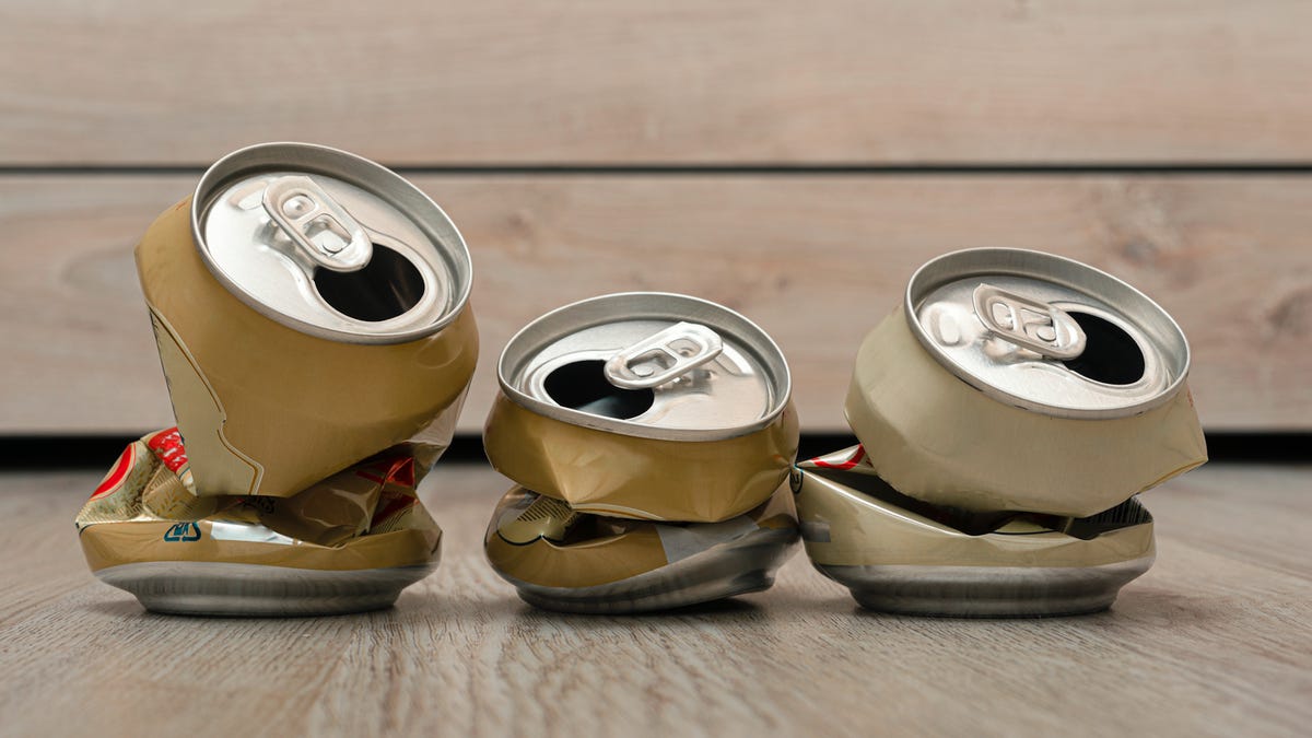 three crushed soda water cans