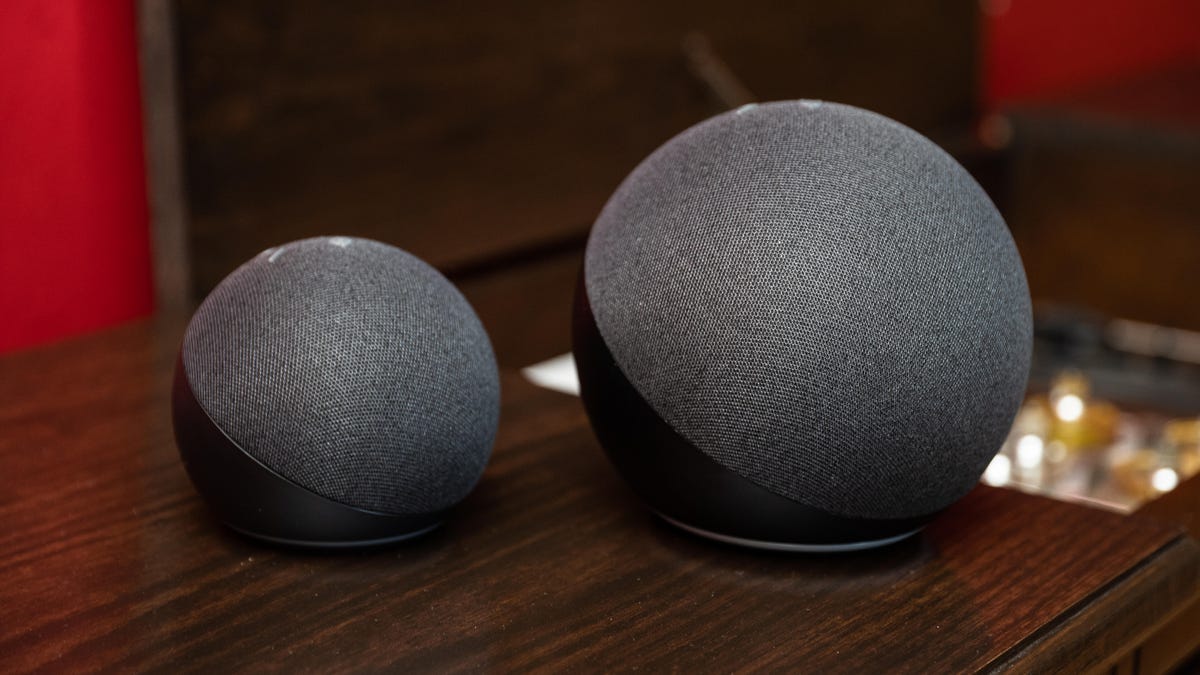 Echo and Echo Dot smart speakers in gray on a wooden table