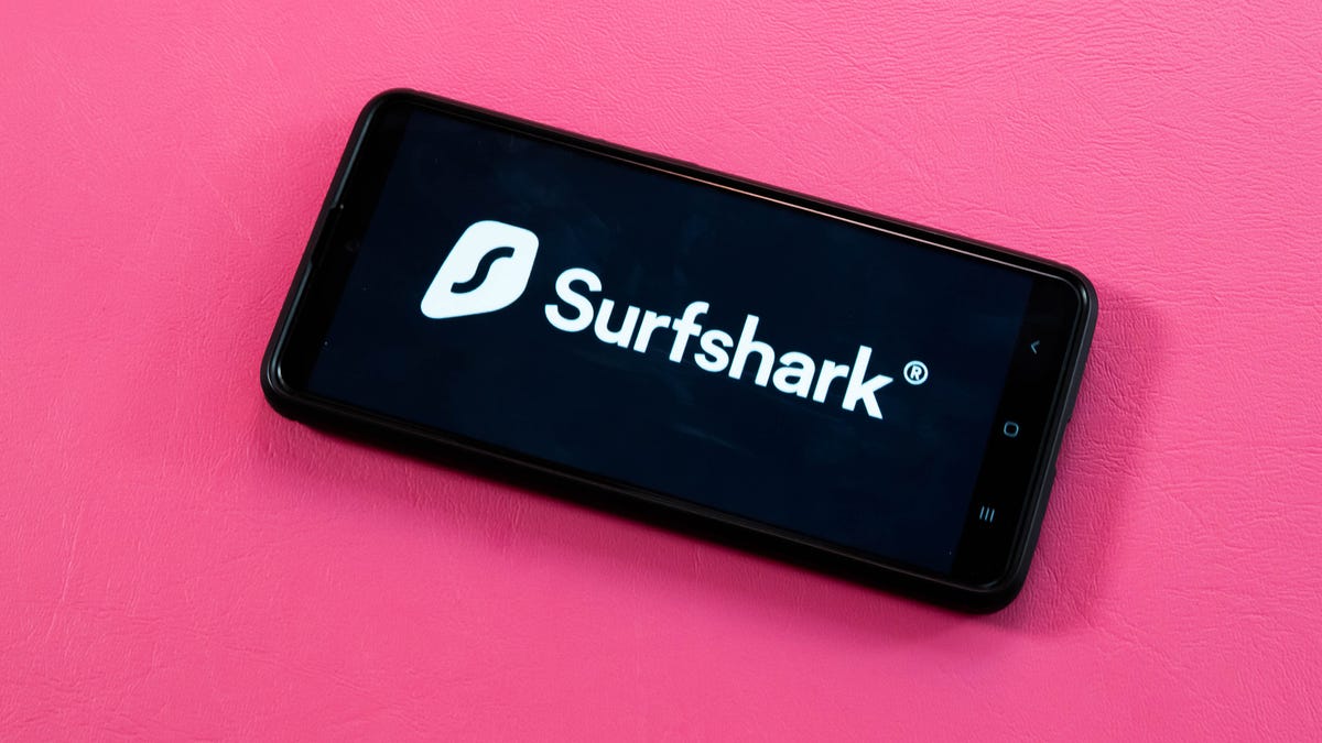 Surfshark logo on a smartphone on a pink background