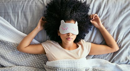 Woman sleeping on her back with a sleep mask on.