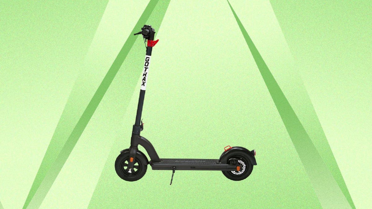 A black and red electric scooter against a green background.