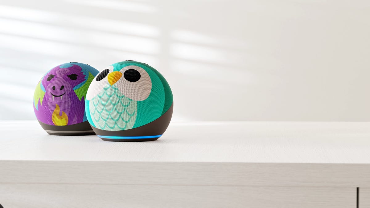 The new Amazon Echo Dot Kids smart speakers, one designed to look like a purple dragon, the other designed to look like a turquoise owl.  Both are spherical in shape with a ring-shaped blue indicator light around the bottom.