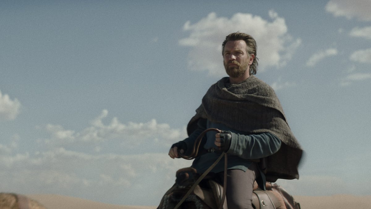 Obi-Wan Kenobi rides through the desert, against a lightly cloudy sky