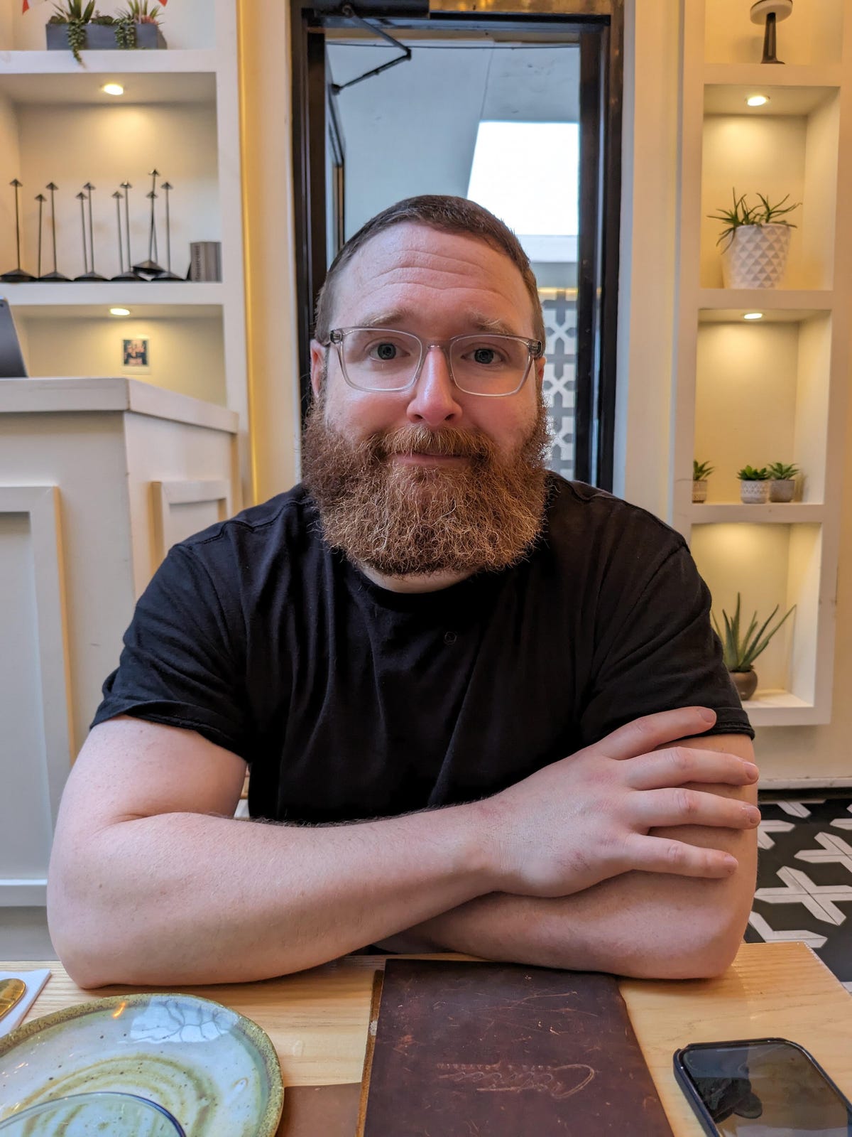 A photo of a man with a beard sitting in a restaurant