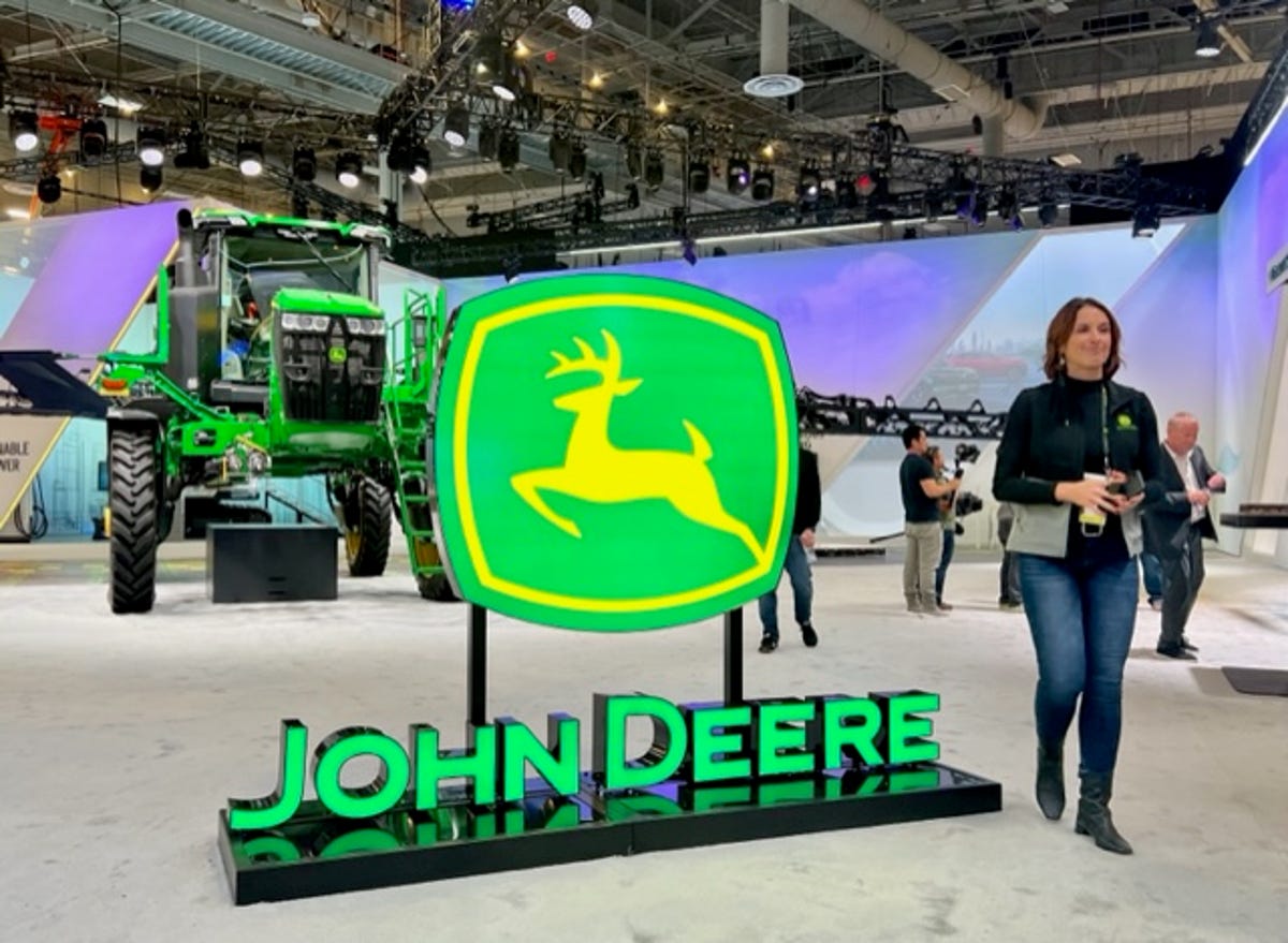 An image of John Deere's logo in front of a tractor at the company's CES booth.