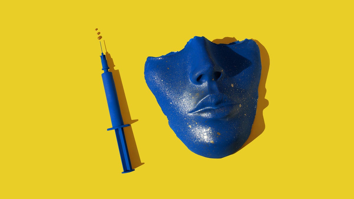 A blue clay mask and syringe against a yellow background