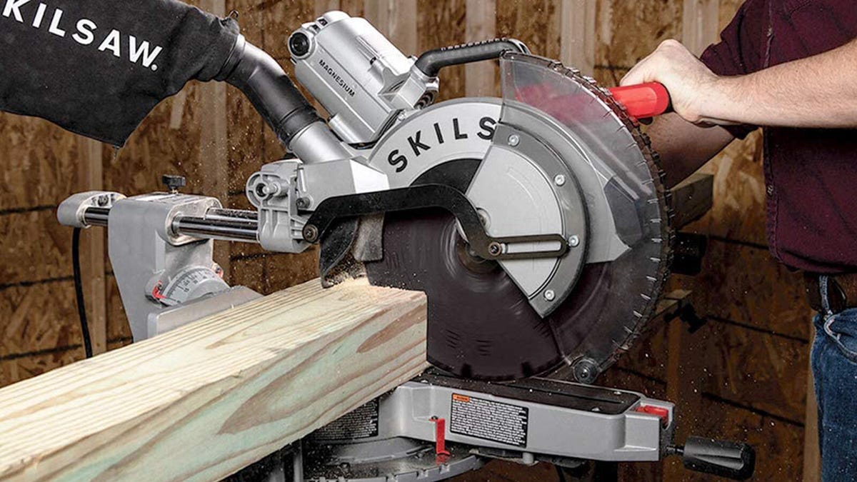 A man cuts through a 4x4 with the Skilsaw worm drive dual bevel sliding miter saw.