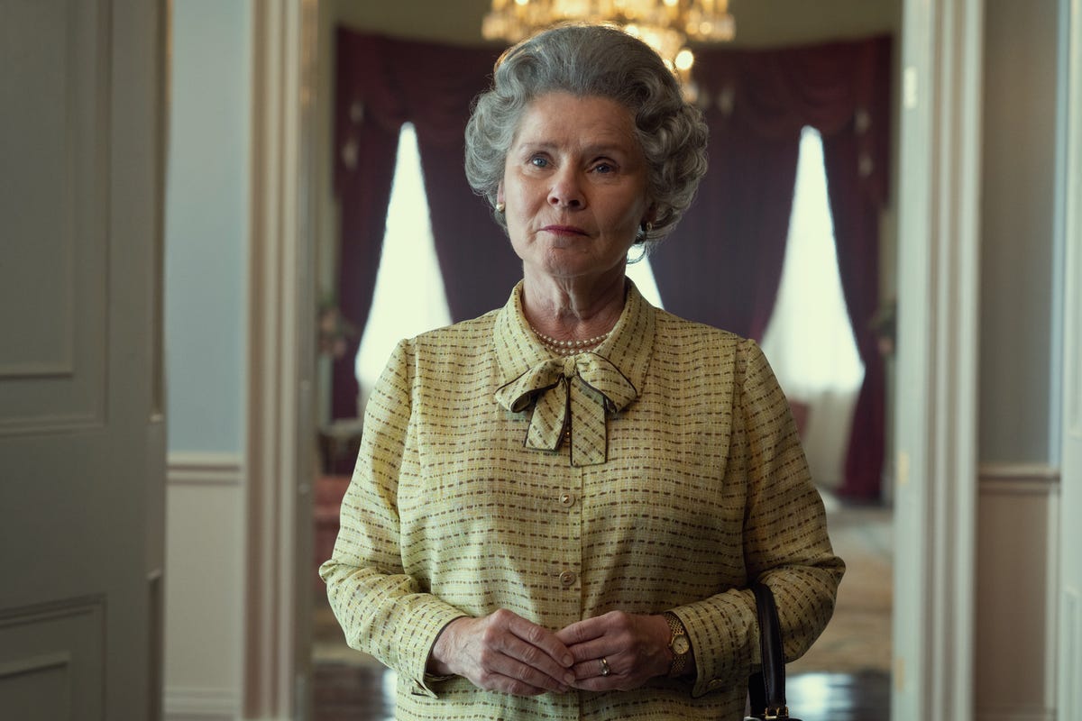 Imelda Staunton as The Queen standing inside looking at something off screen