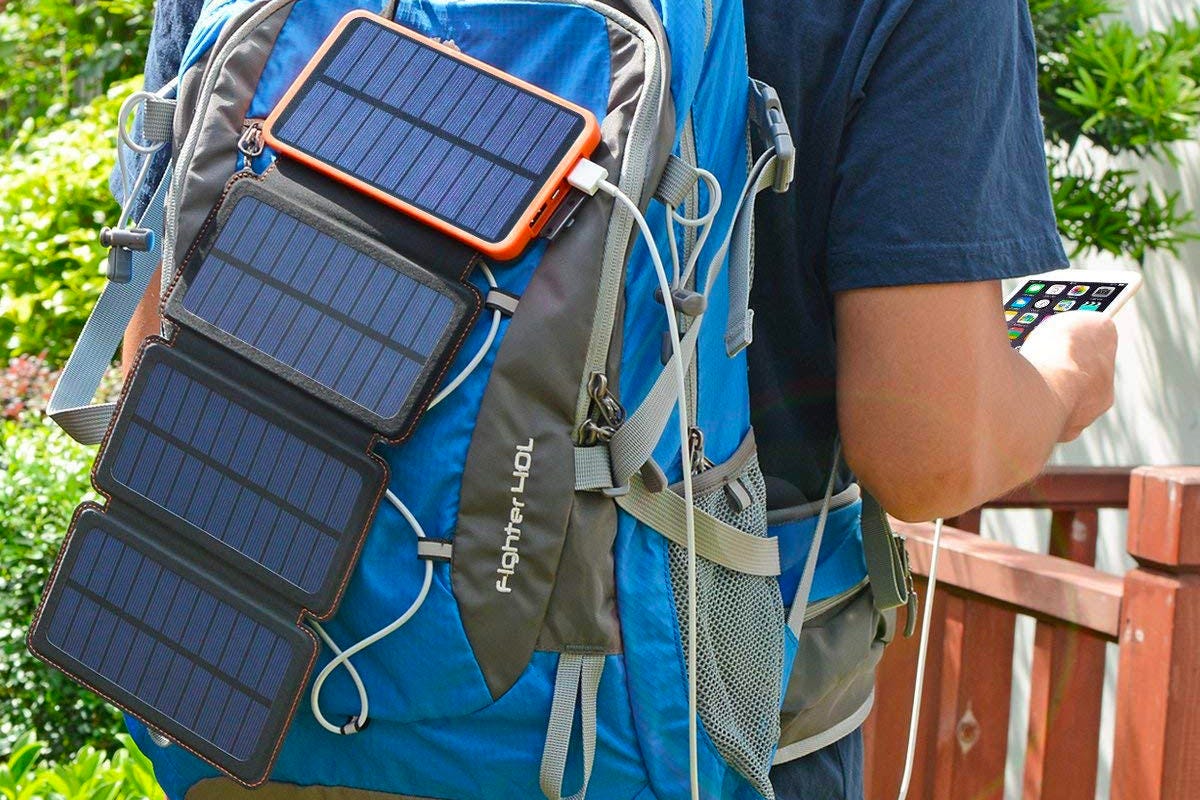 Close-up of solar chargers and household devices attached to a backpack.