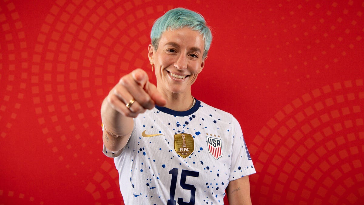 USA soccer team captain Megan Rapinoe smiling and pointing towards the camera.