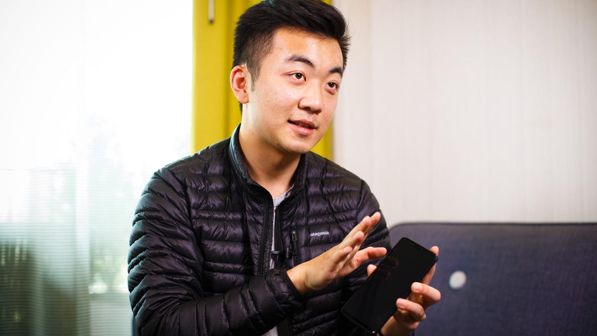 Carl Pei, in a Patagonia jacket, holding a smartphone in his hands