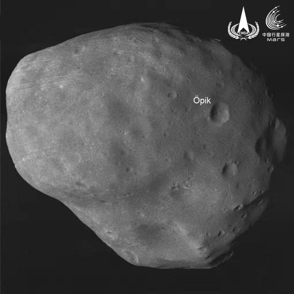 Mars' moon Phobos in black and white looking like a rounded, pockmarked potato.