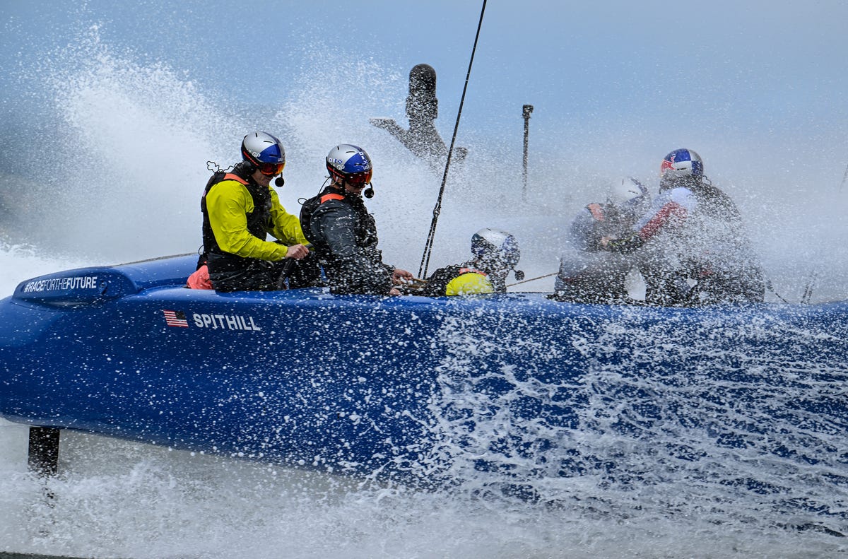 Jimmy Spithill and Team USA are hit by waves during while sailing their F50 sailboat.