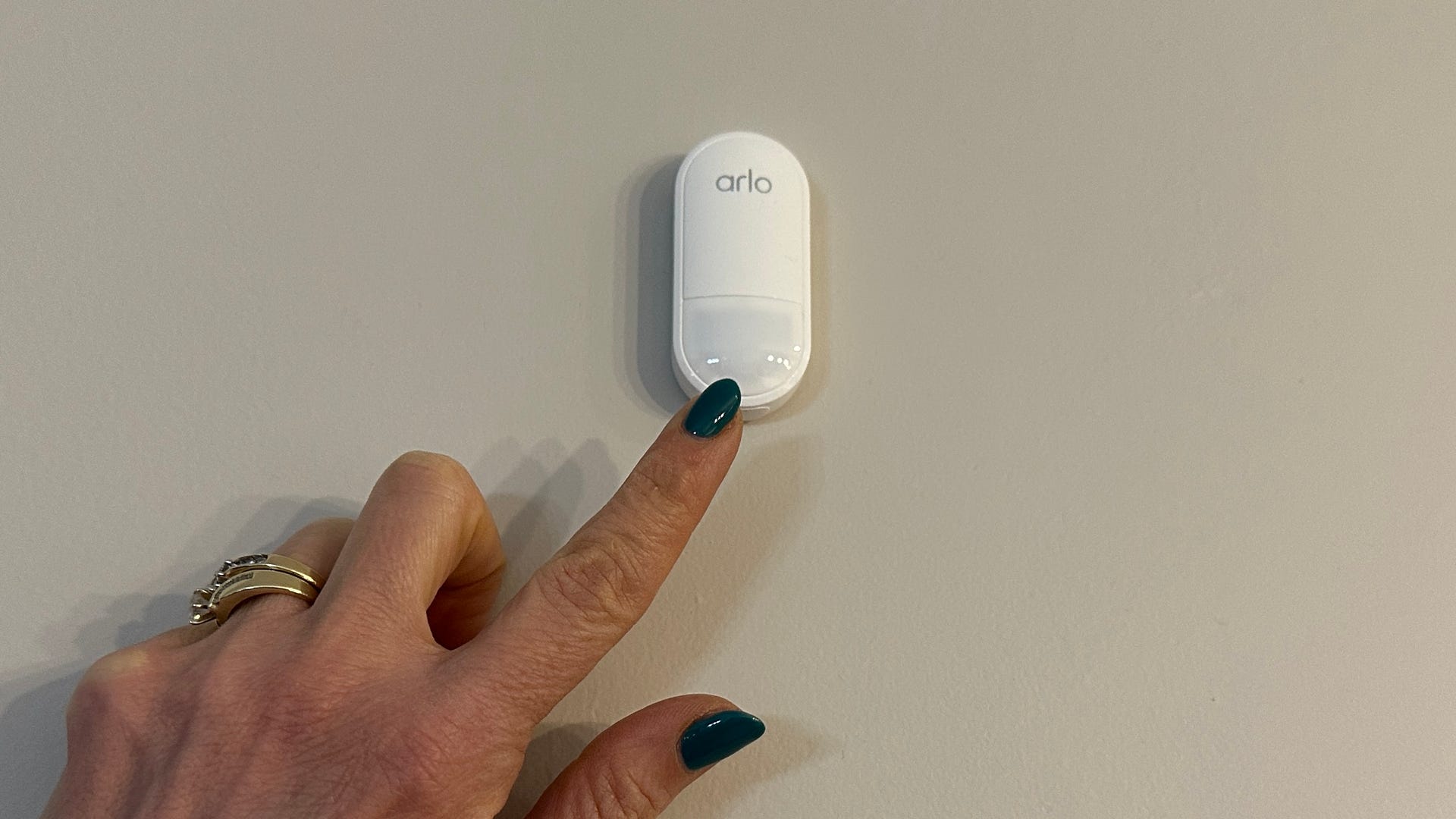 A multi-sensor for the Arlo Home Security System placed against a wall to track motion, temperature, and ambient light. It can also track door or window openings, listen for the sound of smoke or CO alarms, or monitor for leaks.