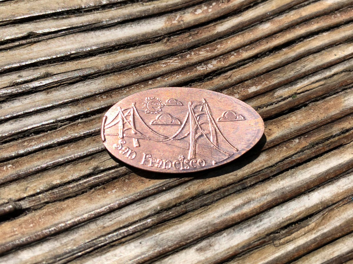 A souvenir smashed penny against the wood of Fisherman's Wharf in San Francisco.