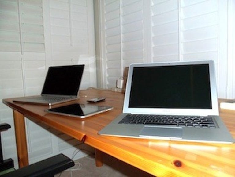 MacBook, iPad 3G, iPhone 3GS, and Windows laptop. The 'essential' entourage that travels with me. How many is too many?