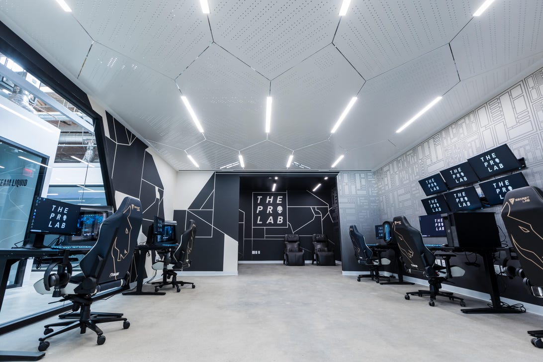 Team Liquid's Pro Lab, with computer stations, a NeurOlympics display with six monitors and zero-point relaxation chairs - all decorated with Alienware desktops and Team Liquid logos.