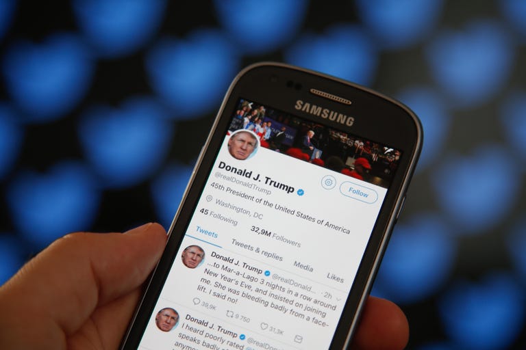 A phone screen showing Donald Trump tweets.