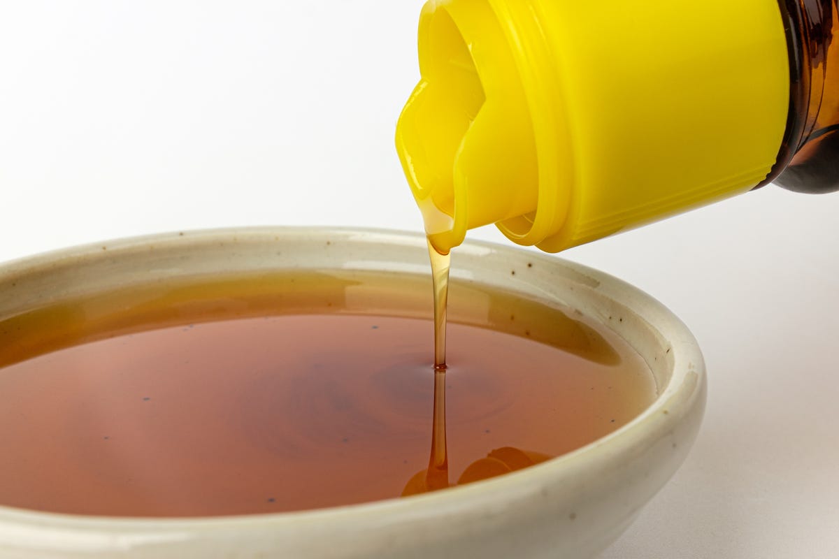 Pouring sesame oil in a small vessel.