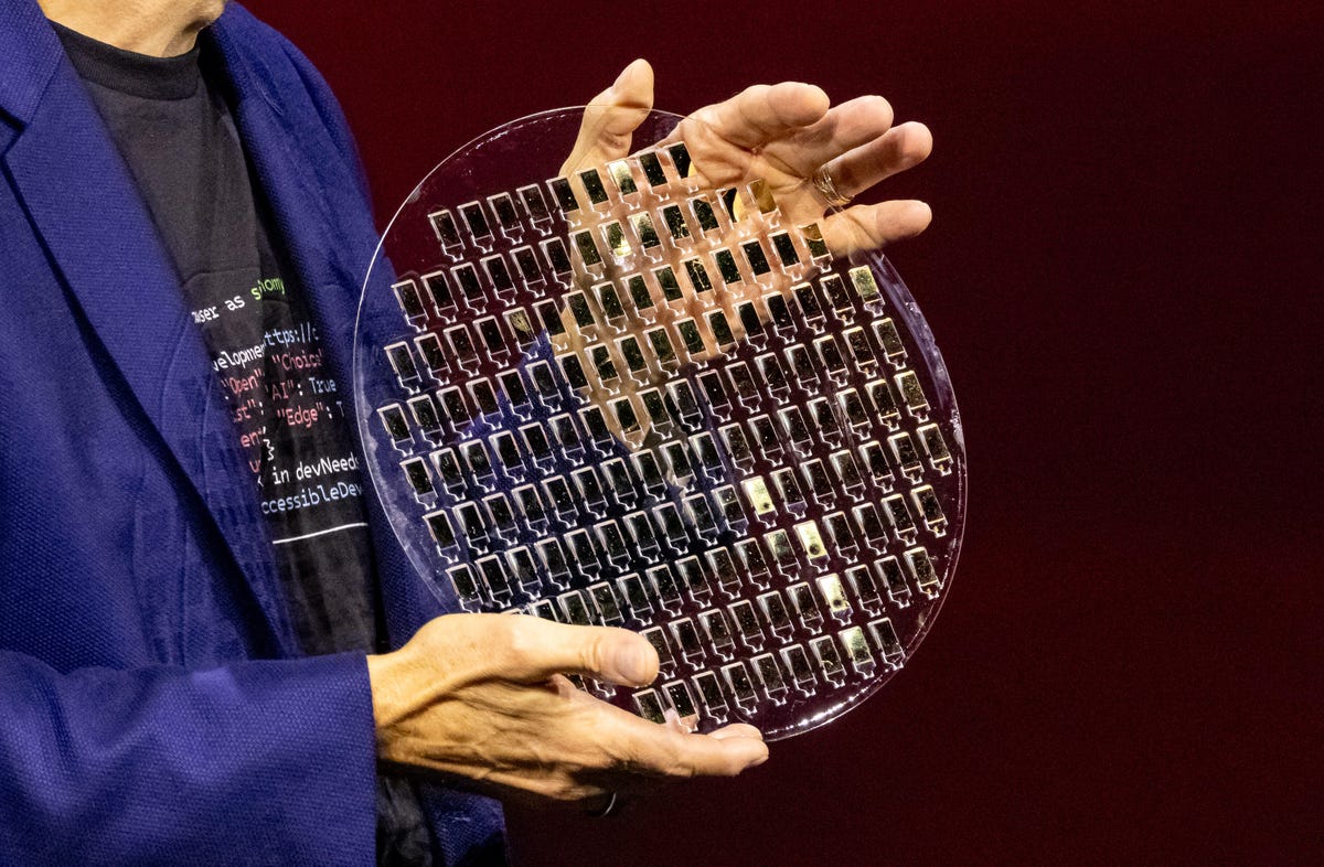 CEO Pat Gelsinger holds a transparent 300mm glass wafer dotted with processors