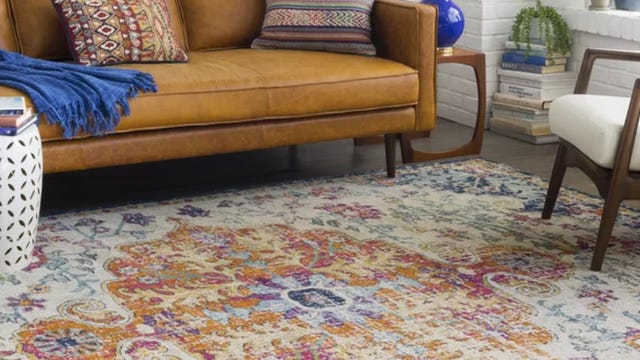 Colorful rug underneath a sofa and side table in a living room