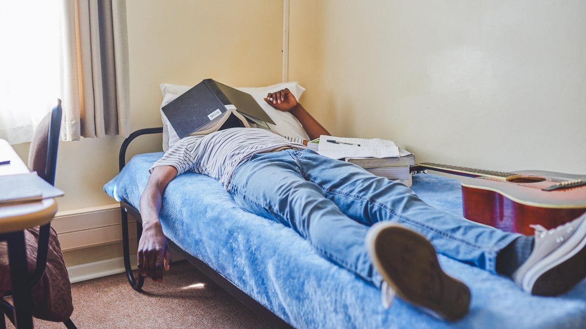 College student sleeping on dorm bed