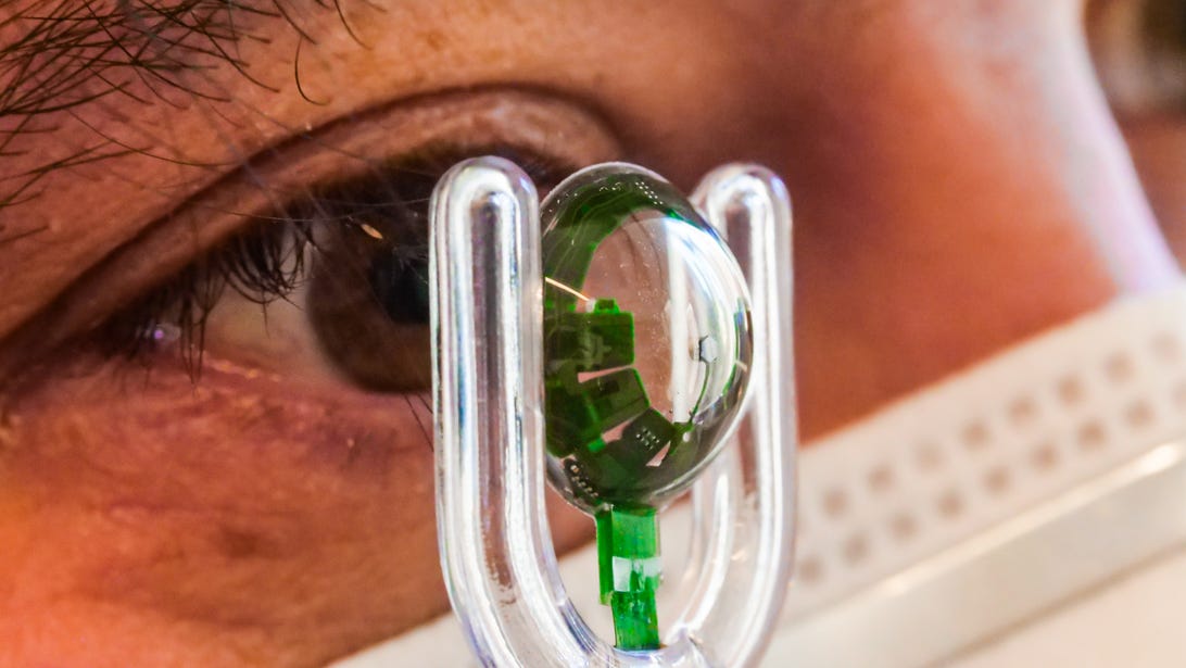 The Mojo Lens high-tech contact lens held up in front of a person's eye