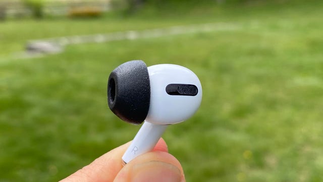 An AirPod Pro earbud with a black Comply foam tip.
