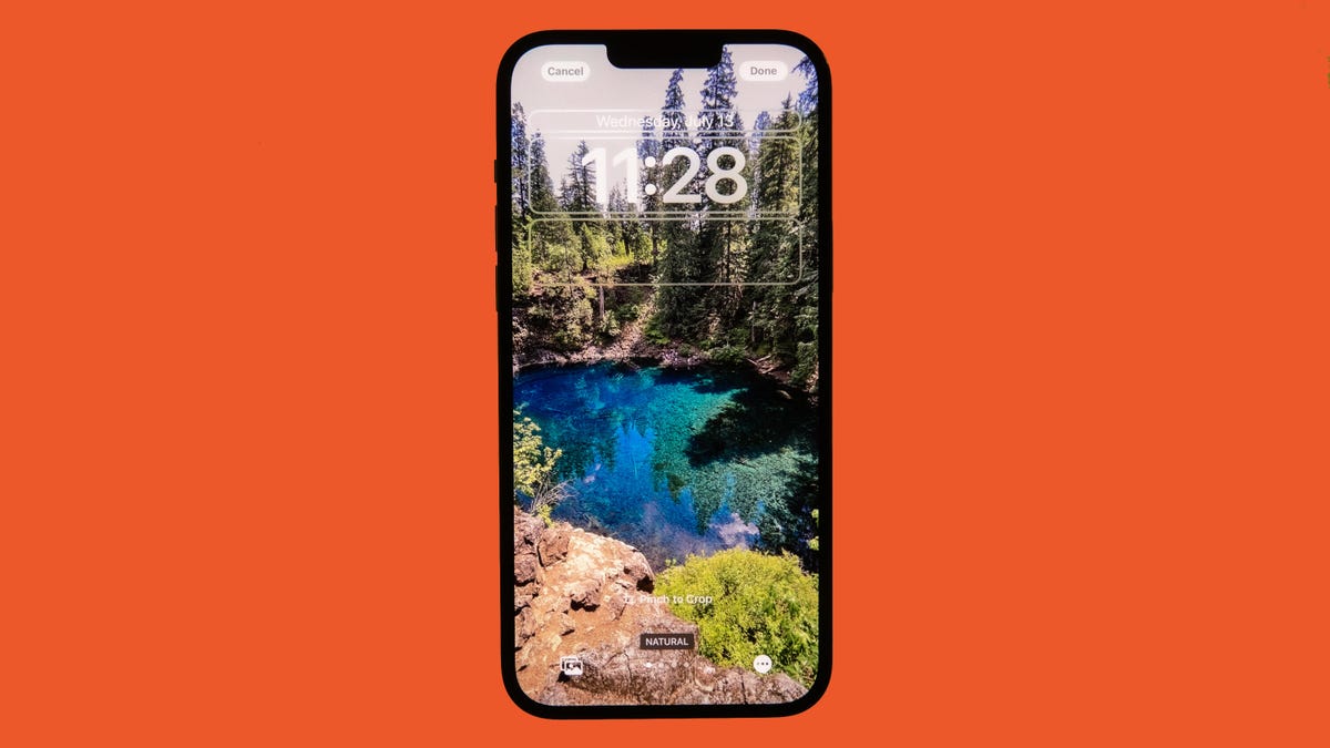 iOS 16 lock screen against an orange background