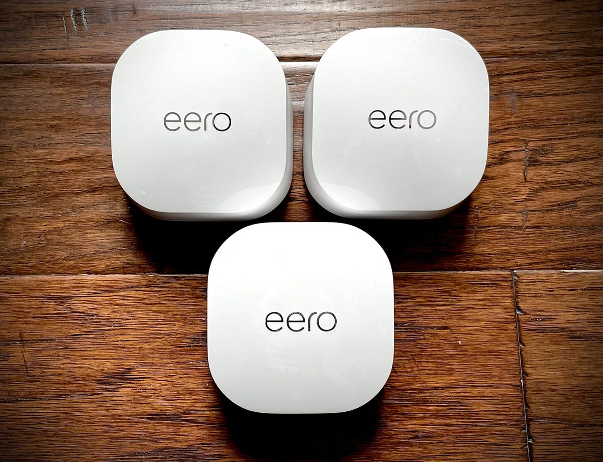 Three Eero 6 Plus unit on top of a wooden table.